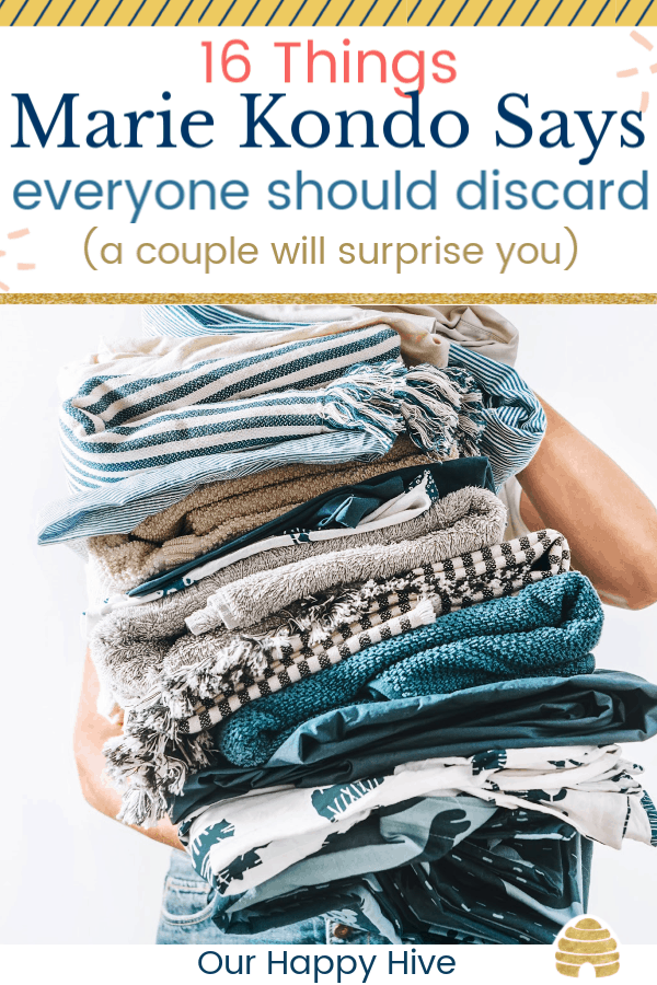 Woman takes in hands big pile blue and beige laundry with text 16 Things Marie Kondo Says Everyone Should Discard