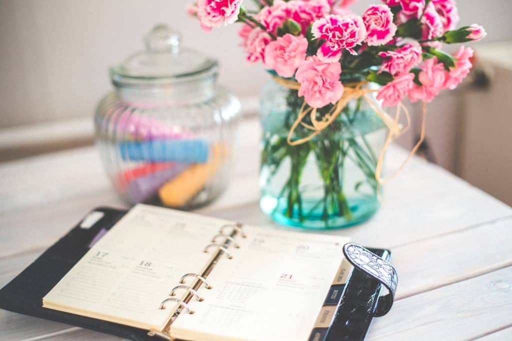 Calendar on a desk with flowers beside it