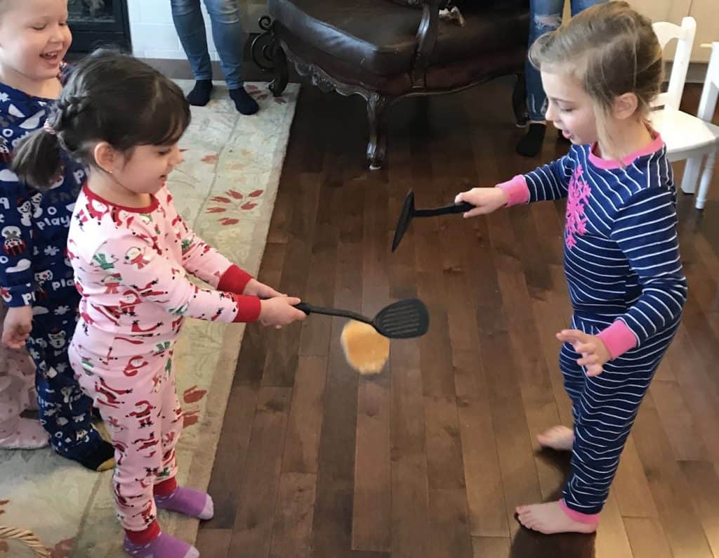 Pancake flipping contest with two preschool girls