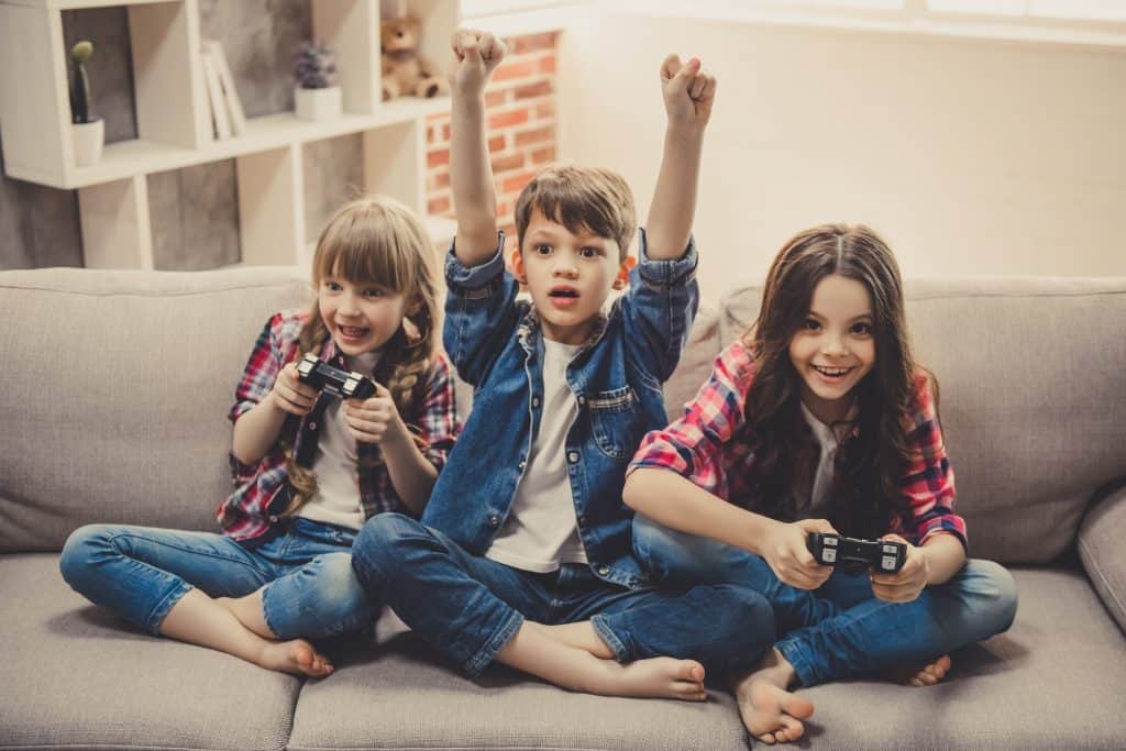 Young kids on a couch playing video games