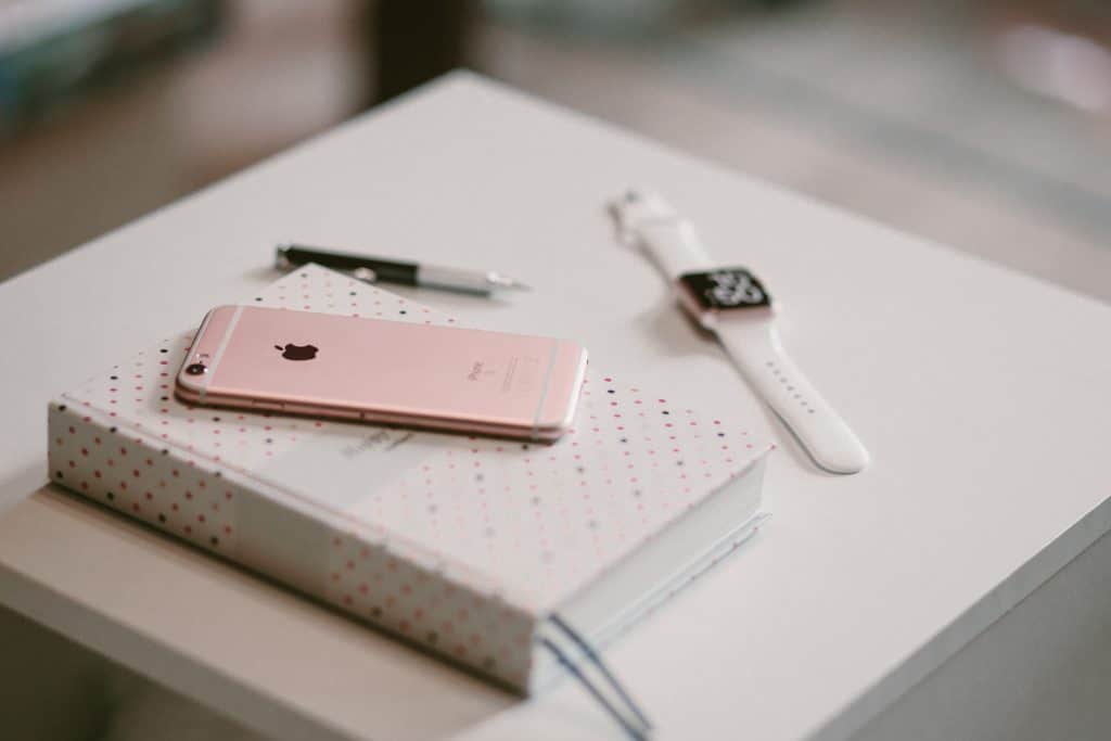 iphone on top of a journal next to an apple watch