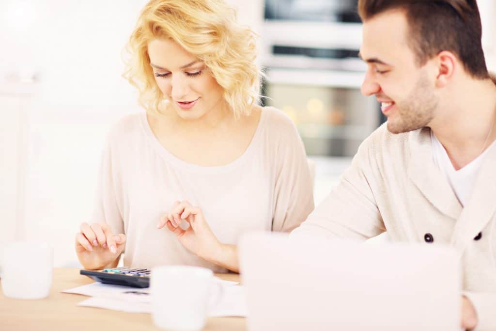 Coulple sitting at table with a calculator