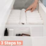 An organized bathrroom drawer with white wash cloths and text 3 steps to an organized home.