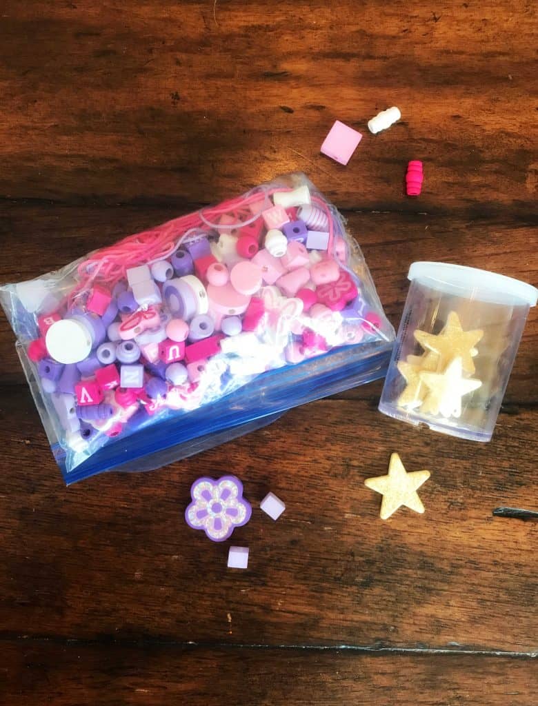 plastic bag with craft supplies including beads and jar with stars