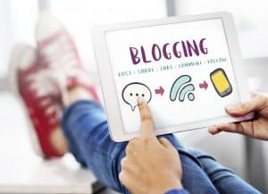 person holding a tablet with the word "blogging"