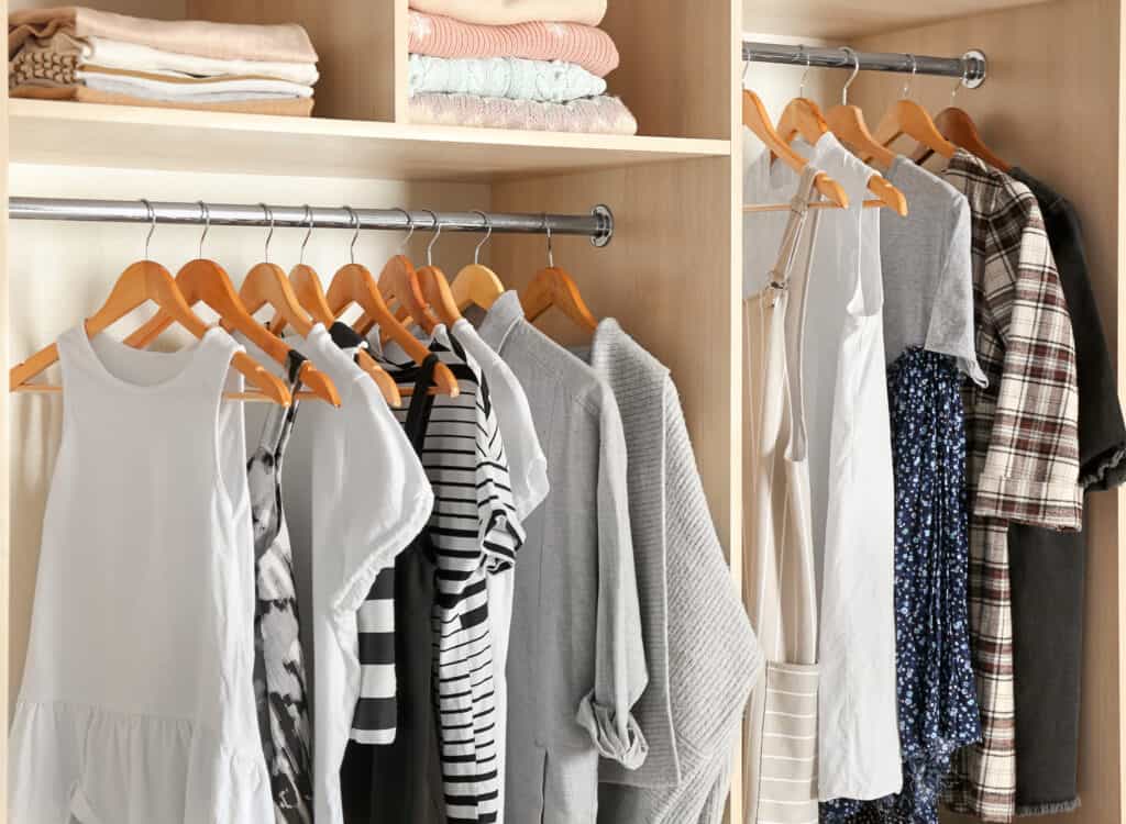 Decluterwomen's clothes hanging in an organized closet after she finished her decluttering project.