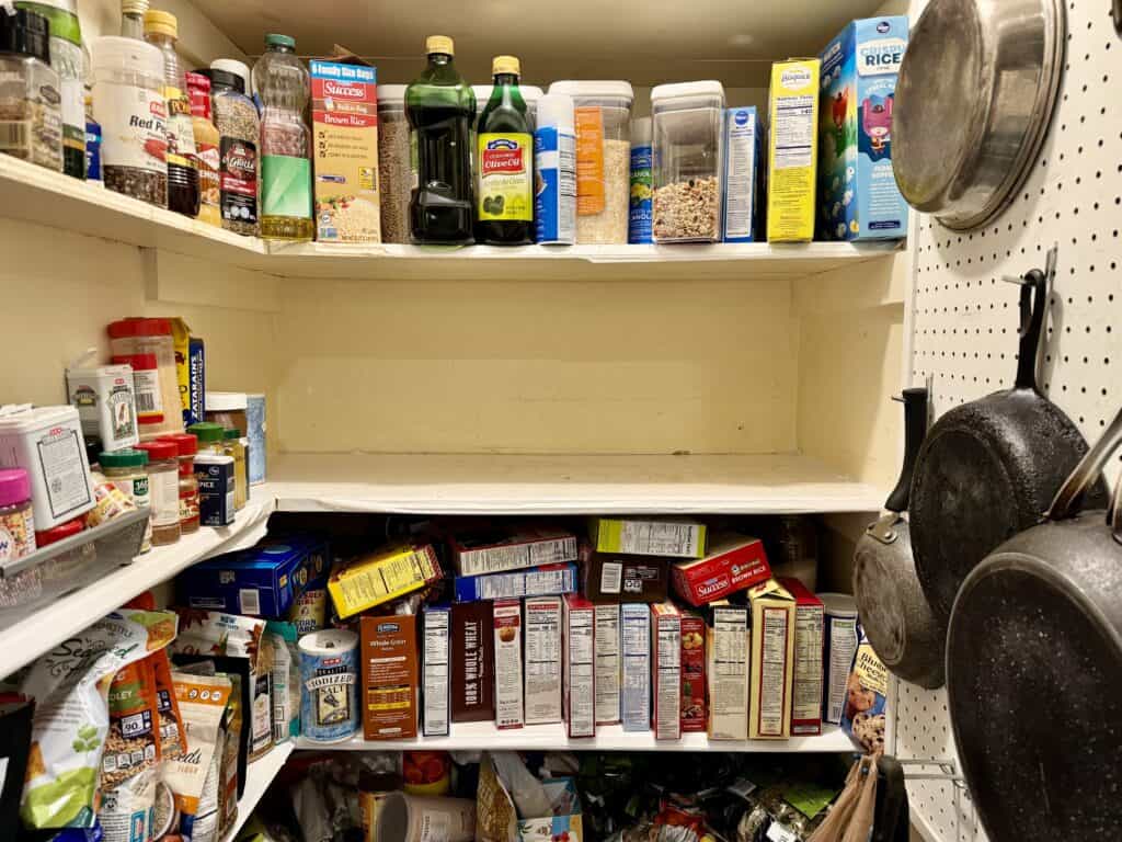 A cluttered deep pantry, showing one shelf cleared off, with the tiny task approach.