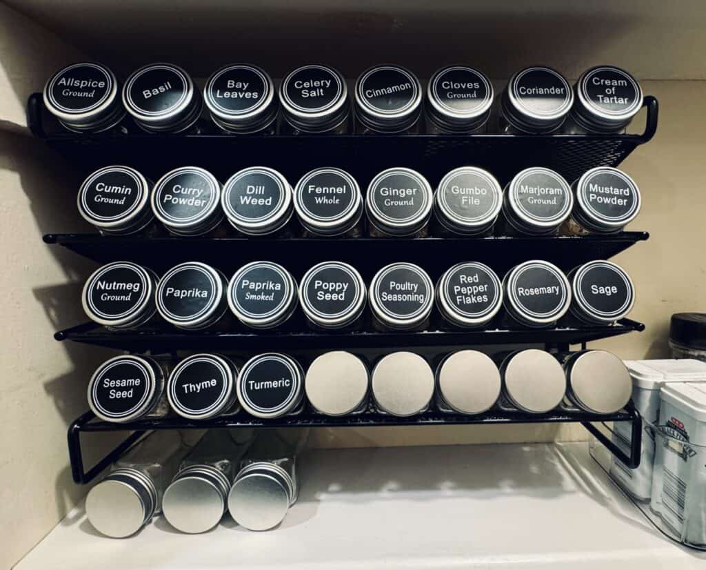 a wire spice rack organizing spices in alphabetical order.  All of the jars are matching and labeled.