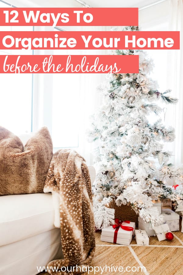 Scenic livingroom decoraed for Christmas with a tree and gifts under the tree and text that says 12 Ways to Organize Your Home before the holidays. 