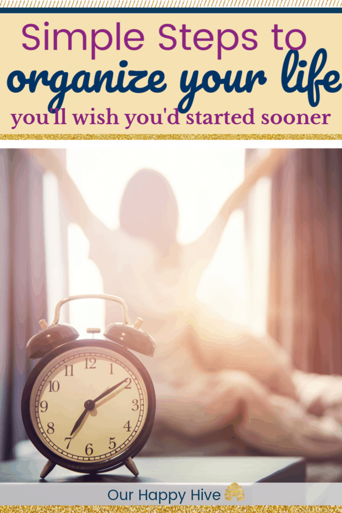 Closeup alarm clock having a good day with background happy mom stretching in bed after waking up, sunlight in morning. with text simple steps to organize your life you'll wish you started sooner