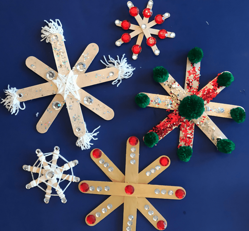 a variety of brightly colored diy popsicle stick snowflakes