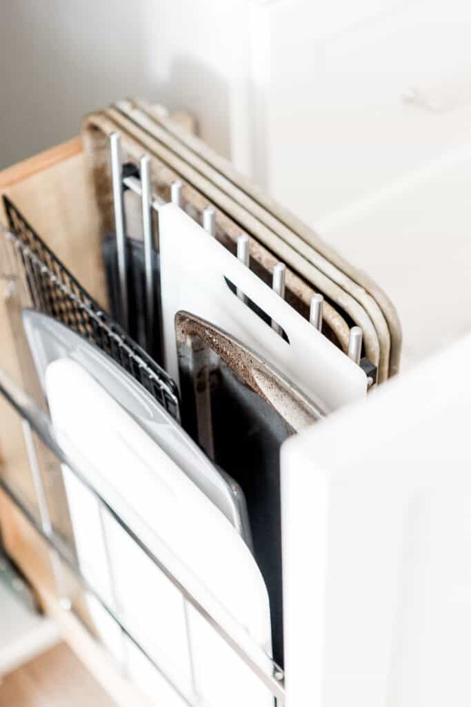 Baking sheets and pans stacked vertically in a drawer demonstrating the vertical filing technique that makes home organization easy.
