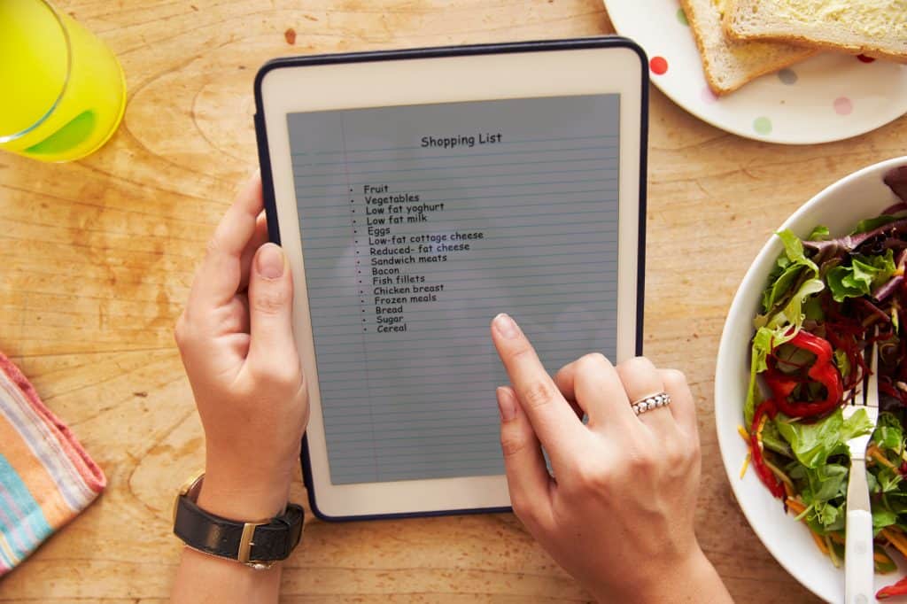 Person At Lunch Looking At To Do List On Digital Tablet