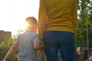 Child holding mothers hand.