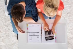 Couple Using Calculator For reviewing their budget.