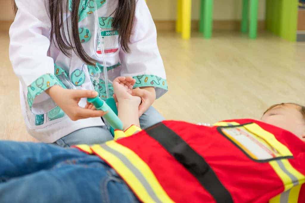 Two kid dress up to fireman and doctor at roll play 