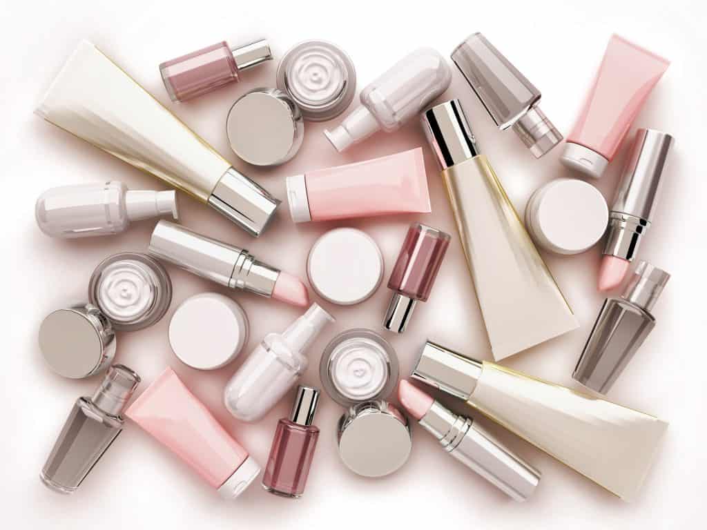 Cosmetic cream, lipstik and perfume on white background. Top view.