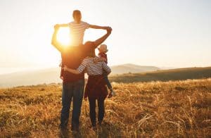 young family looking into the sunset.