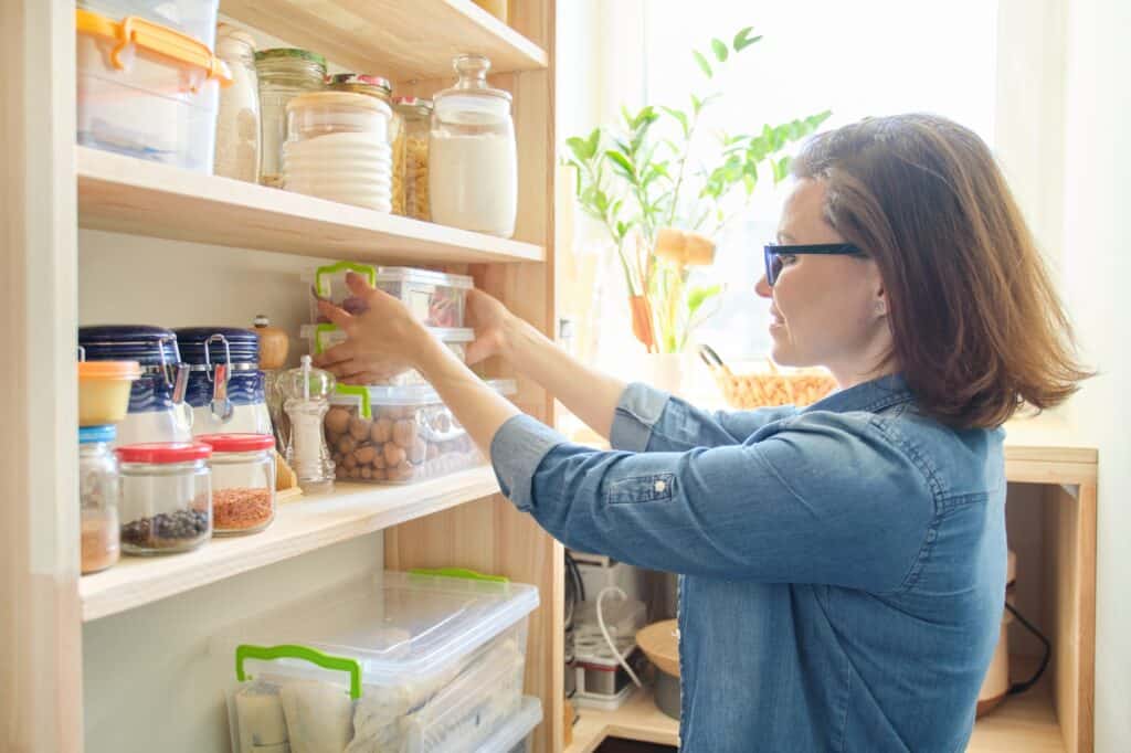 woman standing in front of her organized pantry